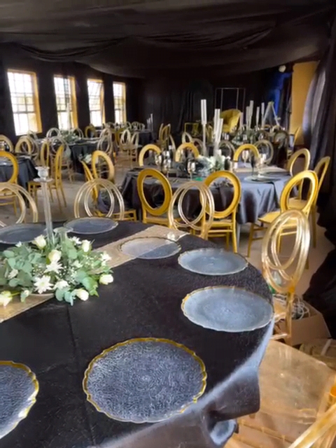 Gala Dinner venue - black and gold table settings with ghost chairs